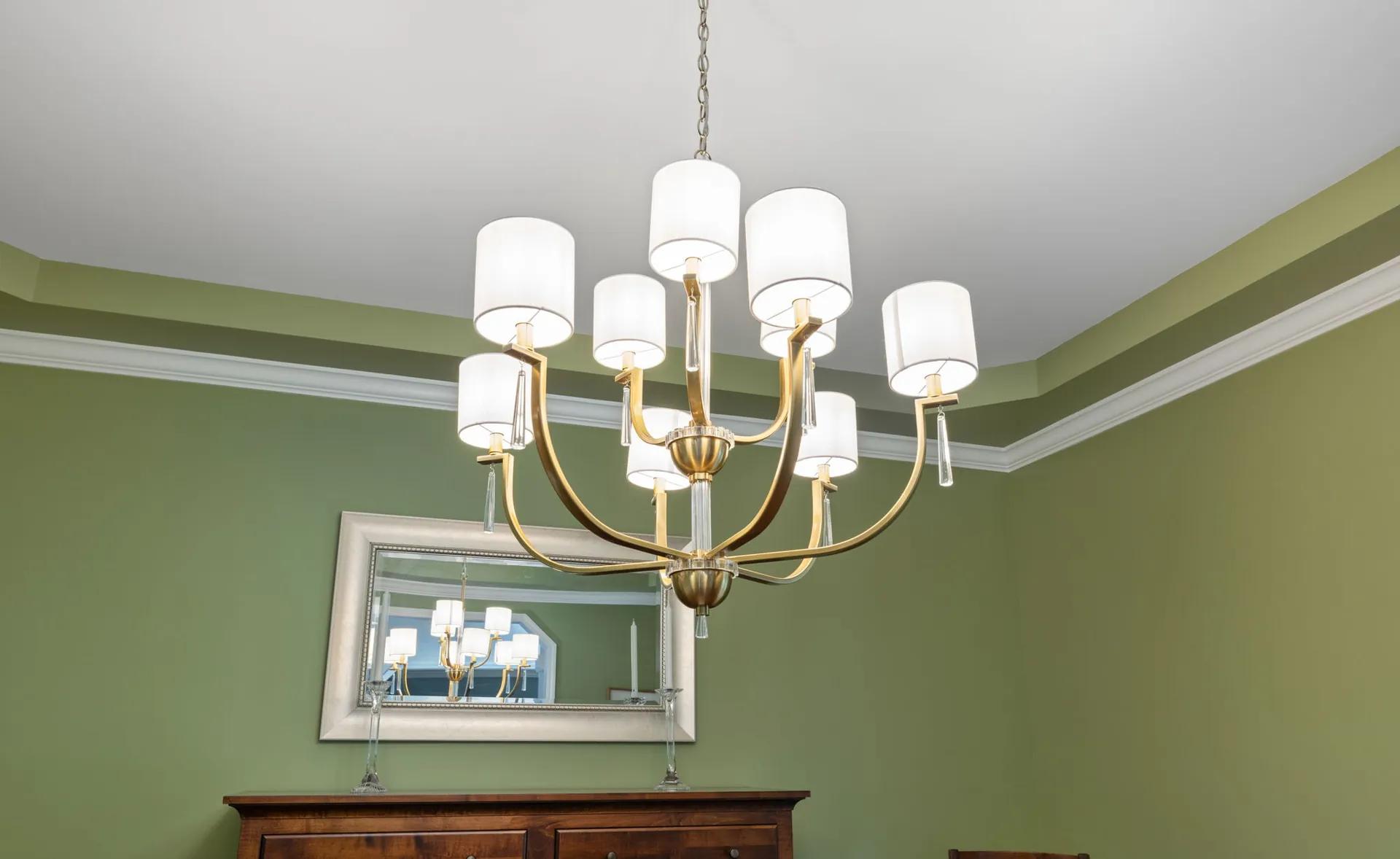 Brass drum shade chandelier in a green tray ceiling dining room