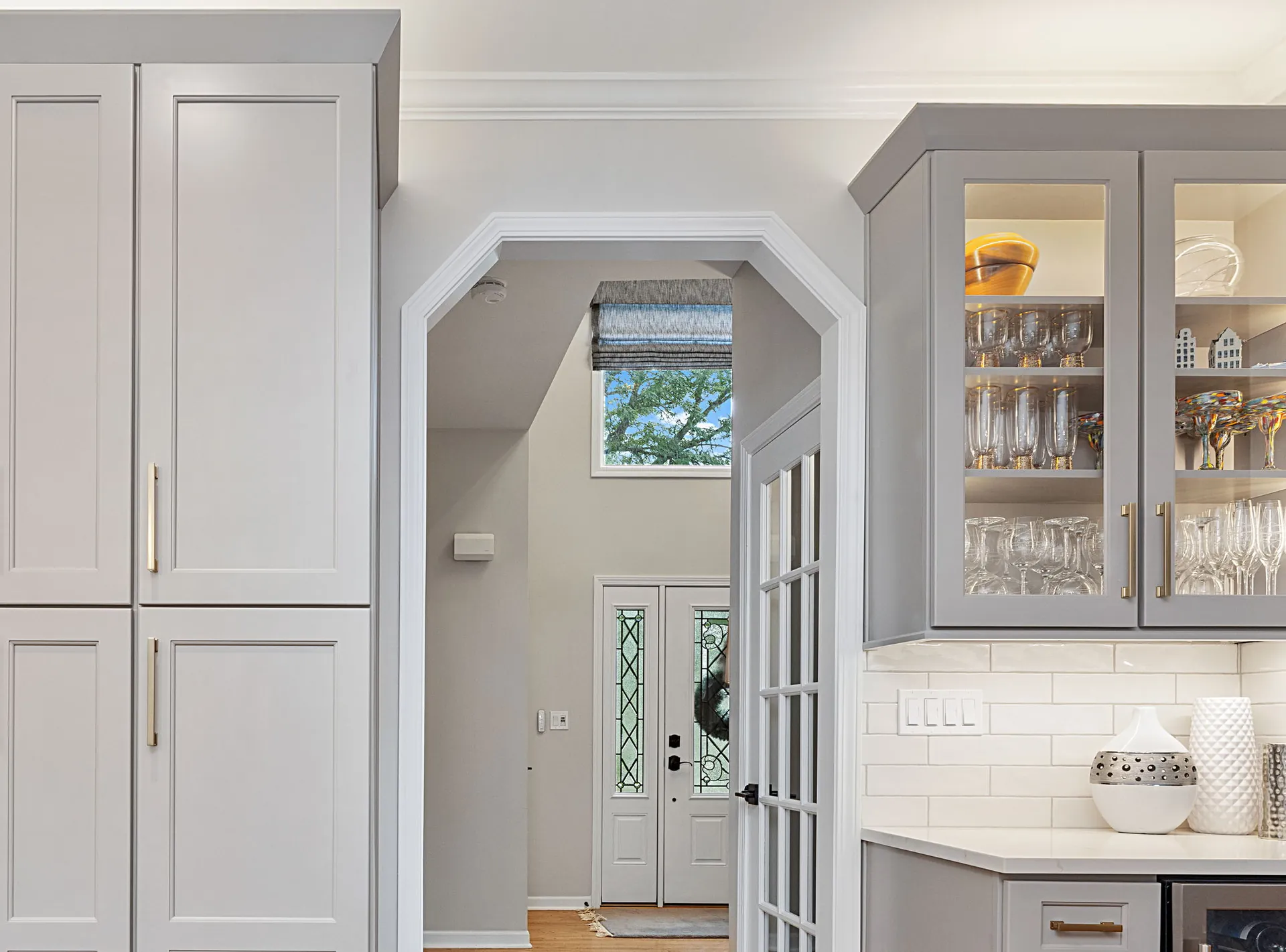 Butler's pantry with glass-front cabinets and lighted glassware storage