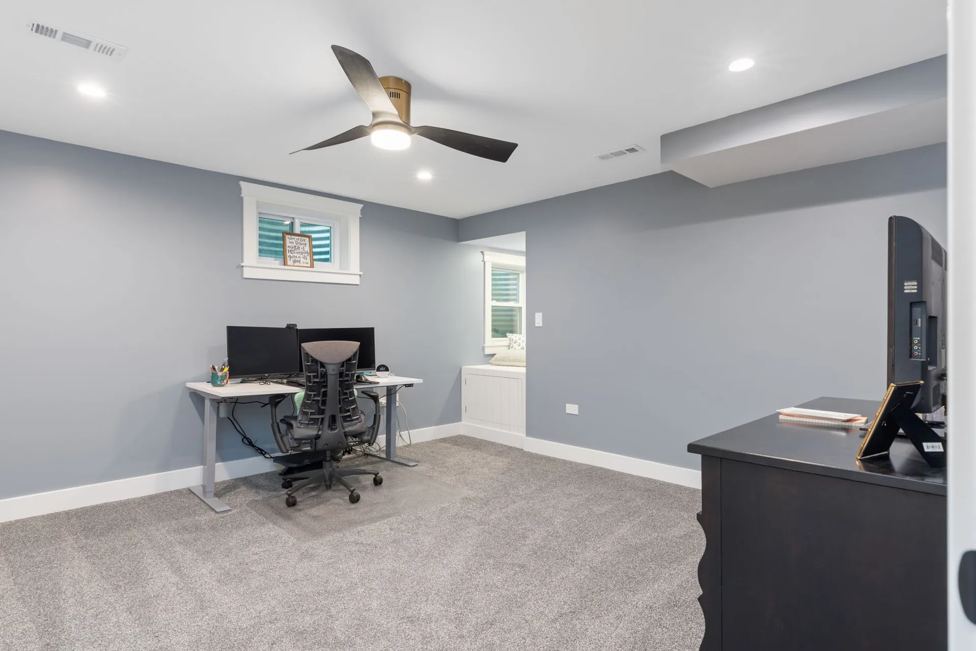 Finished basement office with built-in window seat nook