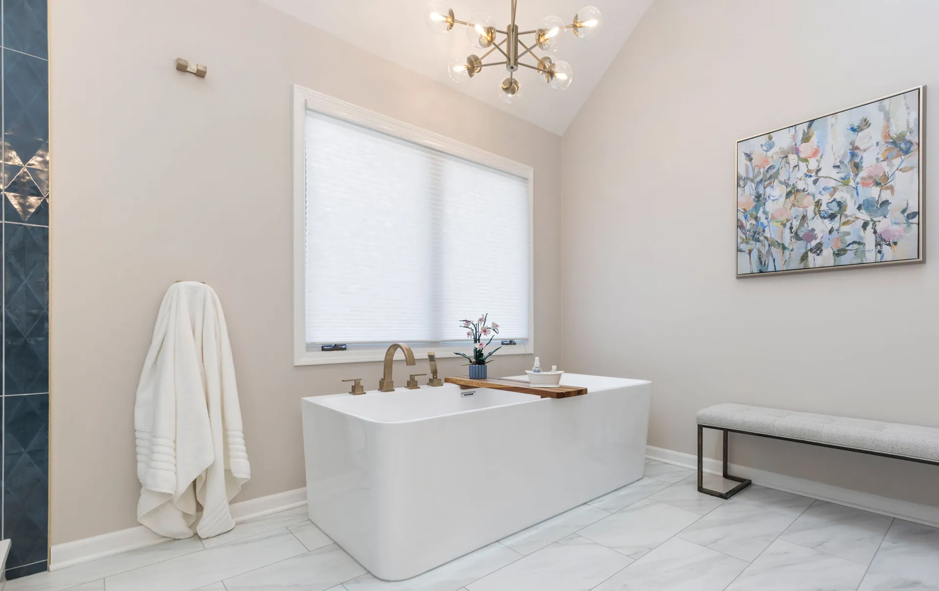 Freestanding soaking tub with brass filler and globe chandelier