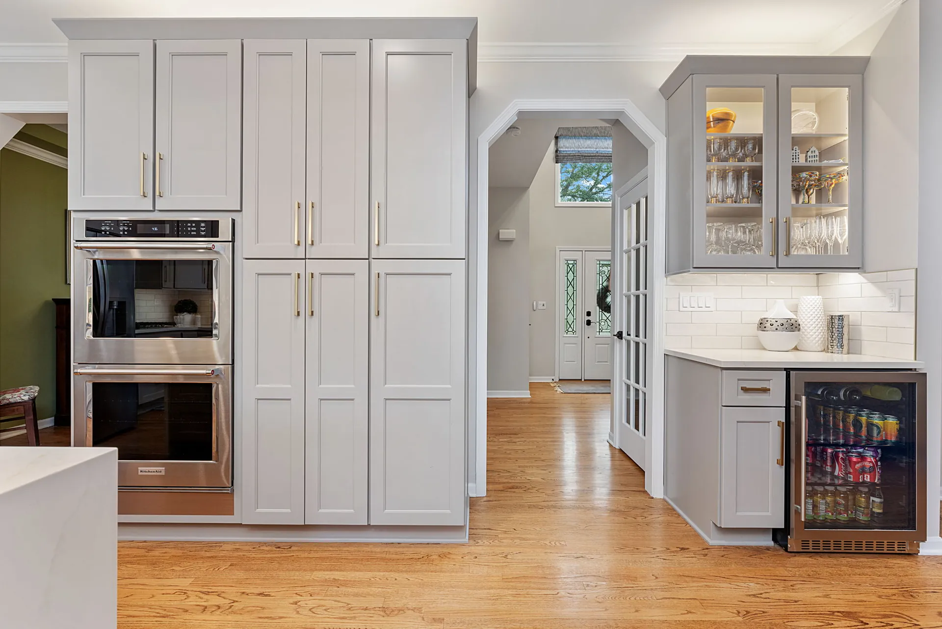 Gray floor-to-ceiling pantry wall with double wall ovens and beverage bar