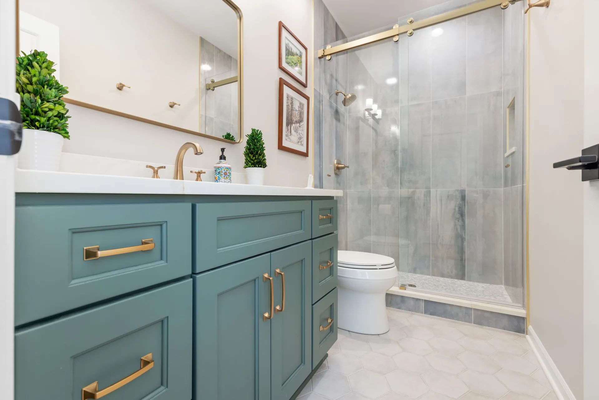 Green vanity with brass hardware and quartz countertop
