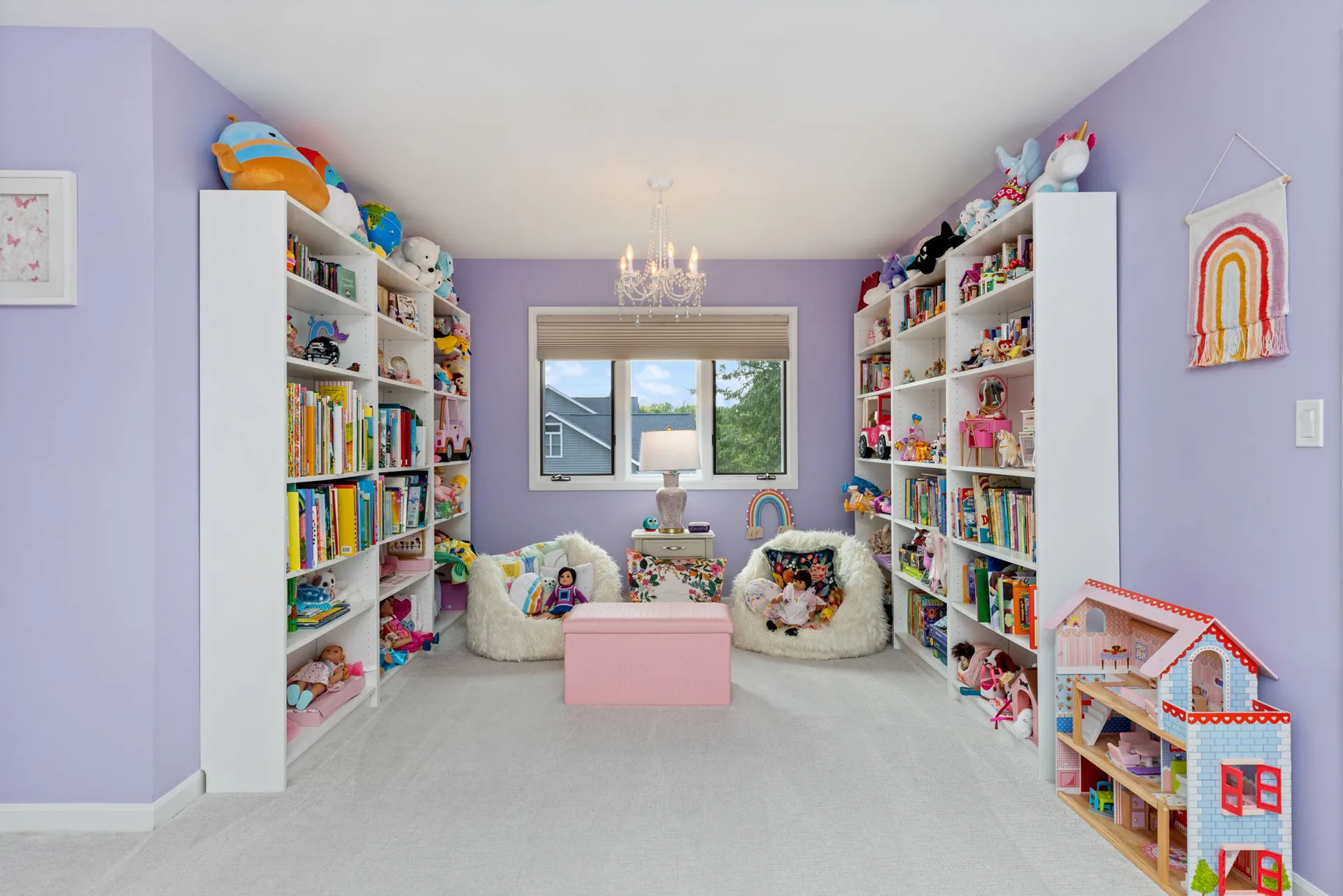 Lavender playroom with white bookshelves and crystal chandelier
