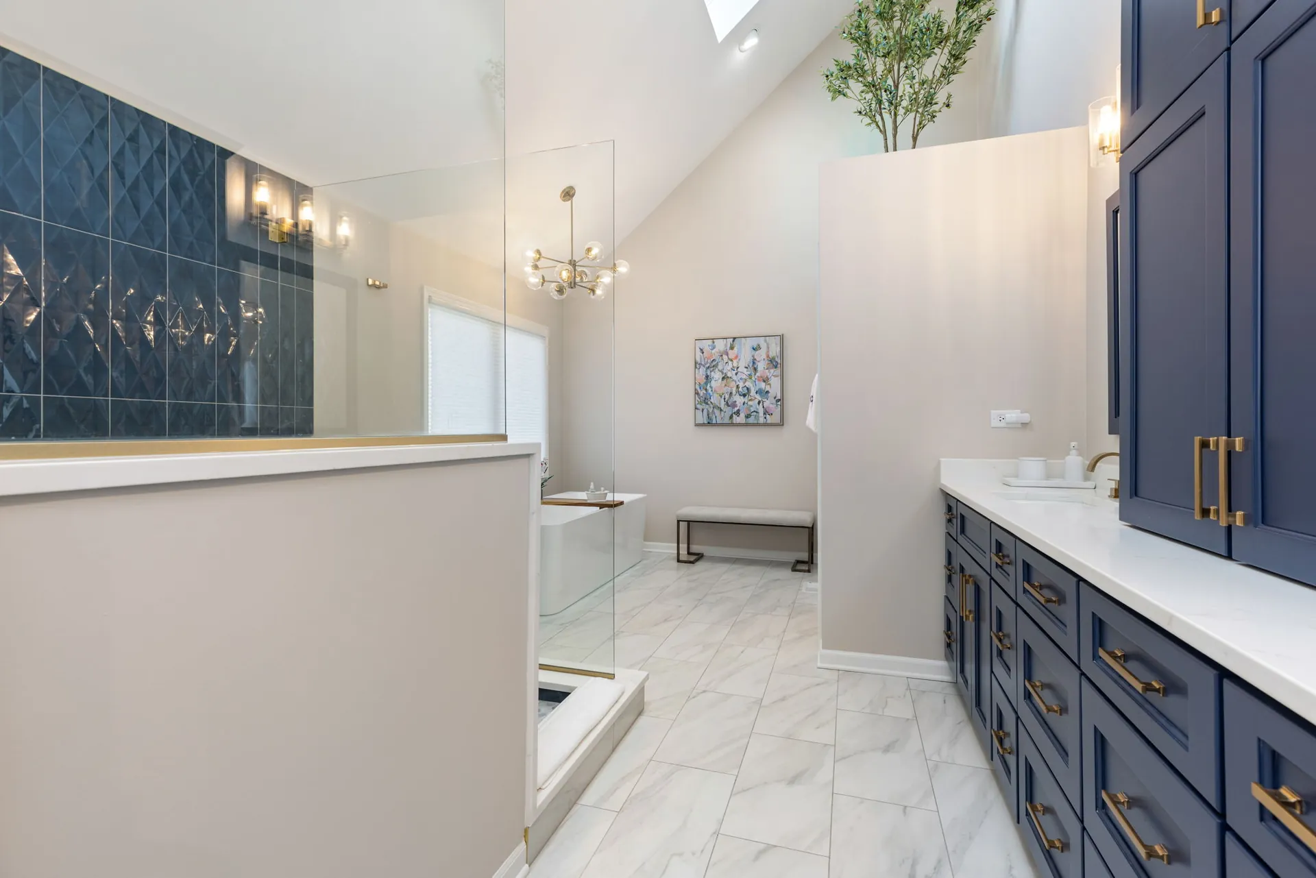 Primary bathroom with navy vanity, blue tile shower and vaulted ceiling